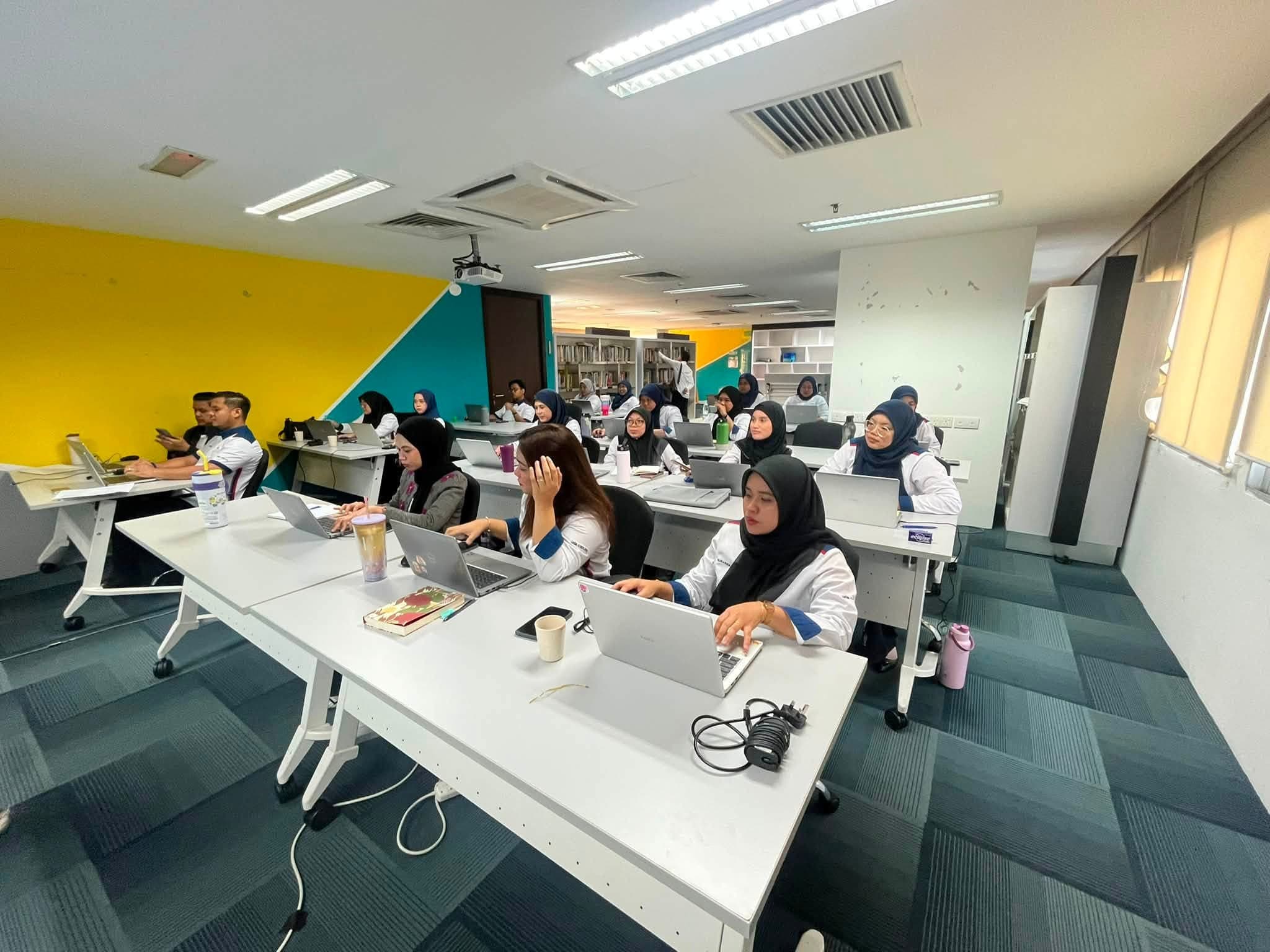 Participants working with laptops in an in-person training session